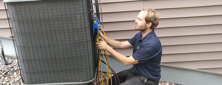 a man servicing and air conditioning unit.