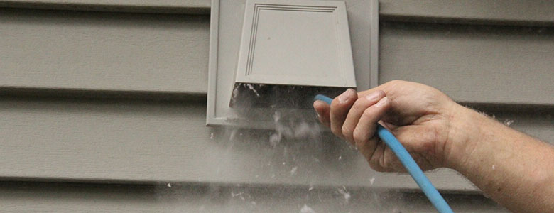 close up shot of a dryer vent being cleaned from the outside.