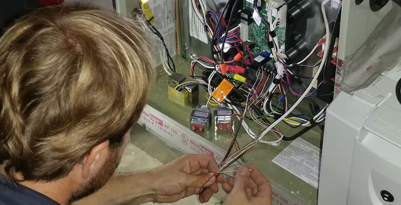 a man servicing and air conditioning unit.